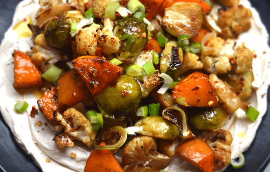 Vegetales asados con soya y miel sobre salsa cremosa de tahine