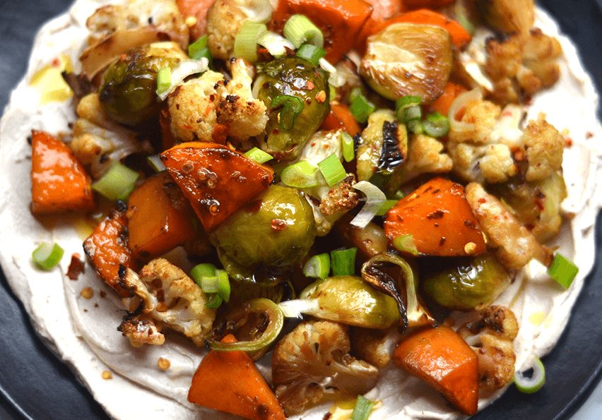 Vegetales asados con soya y miel sobre salsa cremosa de tahine