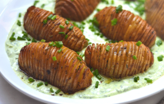 Papas hasselback con crema de queso y hierbas frescas